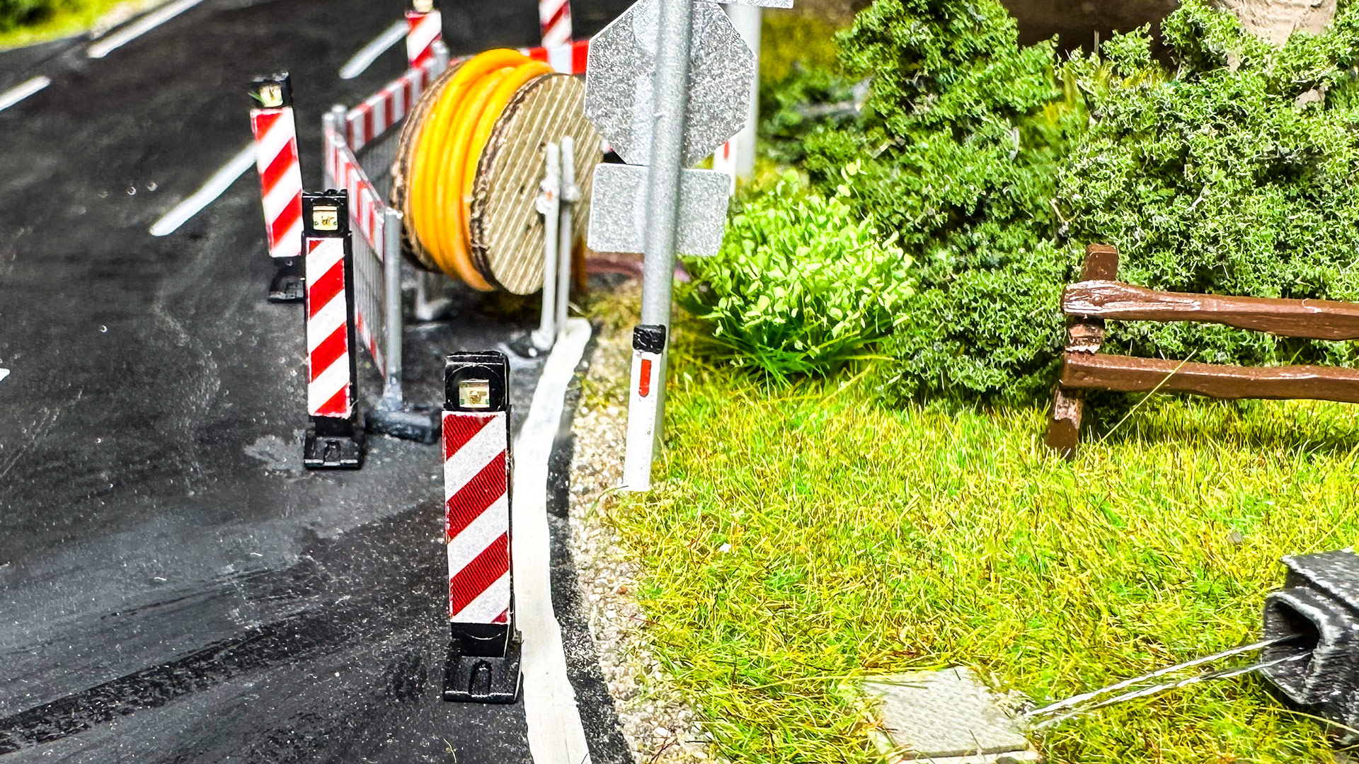 Absperrung einer Straßenhälfte, Kabeltrommel mit Glasfaserschlauch, Warnbaken und Leitpflock
